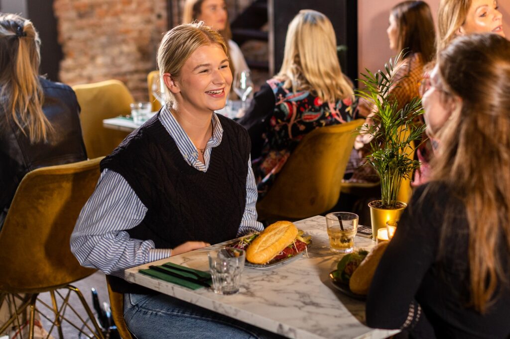 Twee jonge vrouwen zijn vrolijk en lunchen bij Loev Deventer
